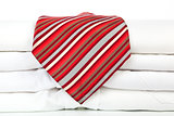 Pile of white shirts with red tie.