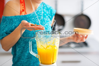Close-up on fitness young woman making pumpkin smoothie in kitch