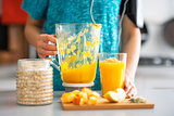 Close-up on fitness young woman with pumpkin smoothie in kitchen
