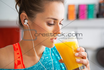 Fitness young woman drinking pumpkin smoothie