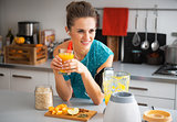 Happy fitness young woman with pumpkin smoothie in modern kitche