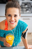 Portrait of happy fitness young woman with pumpkin smoothie in k