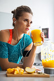 Fitness young woman with glass of pumpkin smoothie in kitchen