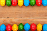 Easter eggs framing an old wooden table surface