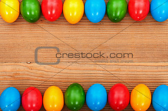 Easter eggs framing an old wooden table surface