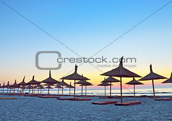 sunrise and umbrellas on beach