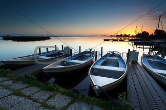 sunrise on lake harbor with boats