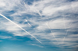 Blue sky with clouds and trails of airplanes