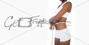 Young woman measuring her waist during diet