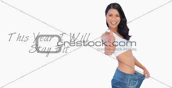 Victorious woman holding her too big pants thumbs up