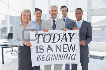 Composite image of business team holding large blank poster