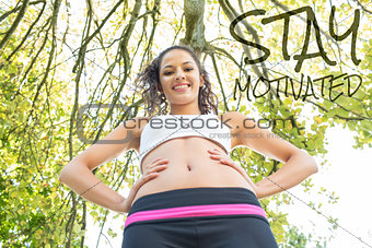 Composite image of active happy brunette standing hands on hips smiling