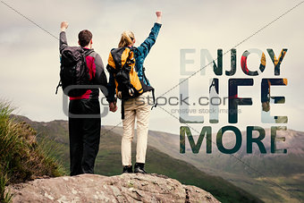 Composite image of excited couple reaching the top of their hike and cheering