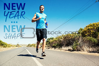 Composite image of athletic man jogging on open road holding bottle