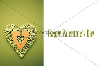 Composite image of wicker heart ornament with green paper cut out