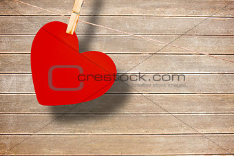 Composite image of heart hanging on line