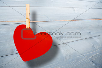 Composite image of heart hanging on line