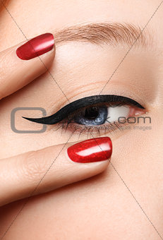 Glamour black arrow makeup close with fashion red nails on face