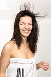 Attractive woman in a towel blow drying her hair