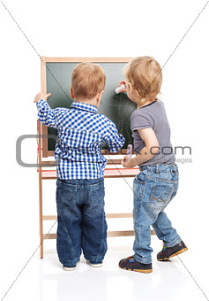 Toddler boys drawing on chalkboard over white background