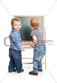 Toddler boys drawing on chalkboard over white background