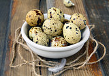 Quail eggs in a bowl on a wooden table