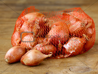 natural organic red shallot onion on a wooden background