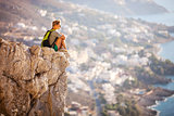 Young woman sitting on rock and enjoying beautiful view