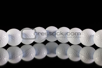 Golf balls on the black glass desk