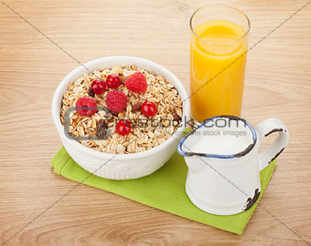 Healty breakfast with muesli, berries, milk and orange juice