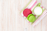 Colorful macarons and cup of milk