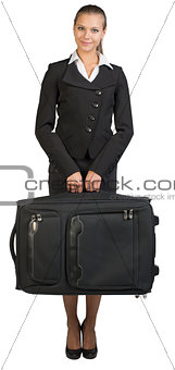 Businesswoman holding suitcase, looking at camera, smiling