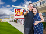 Hispanic Couple with Keys In Front of Home and Sign