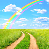 Rural landscape with old road and rainbow