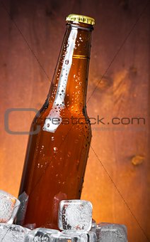 bottle of fresh beer with drops and ice, with space for text