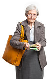 Senior woman counting money while standing over white background