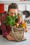 Happy young housewife enjoying freshness of vegetables from loca