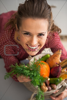 Portrait of happy young housewife with shopping bag of fresh veg