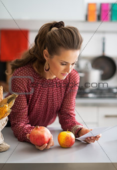 Young housewife exploring checks after grocery shopping in kitch