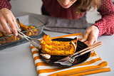 Closeup on young housewife serving baked pumpkin