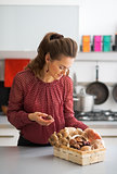 Young housewife with basket with mushrooms in kitchen