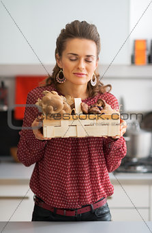 Young housewife enjoying freshness of mushrooms in basket