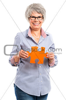 Elderly woman holding a puzzle piece
