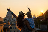 Silhouette of mother and baby girl looking on rooftops of rome o