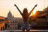 Young woman looking on rooftops of rome on sunset and rejoicing.