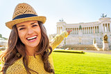 Portrait of happy young woman pointing on piazza venezia in rome