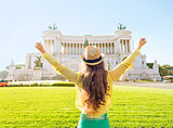Young woman on piazza venezia in rome, italy rejoicing. rear vie