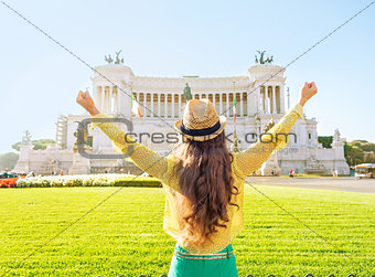 Young woman on piazza venezia in rome, italy rejoicing. rear vie