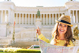 Happy young woman with map pointing on piazza venezia in rome, i