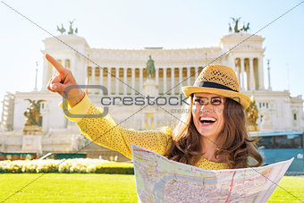 Happy young woman with map on piazza venezia in rome, italy poin